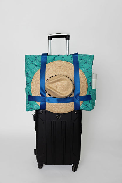 green and blue solmate tote with straps to carry wide brim hat on carry on suitcase